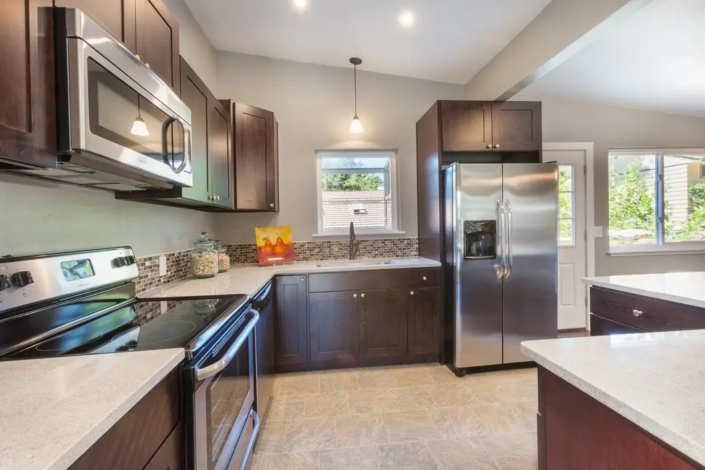 Compact kitchen with dark cabinetry, granite counters and stainless appliances in a Northeast Ohio home